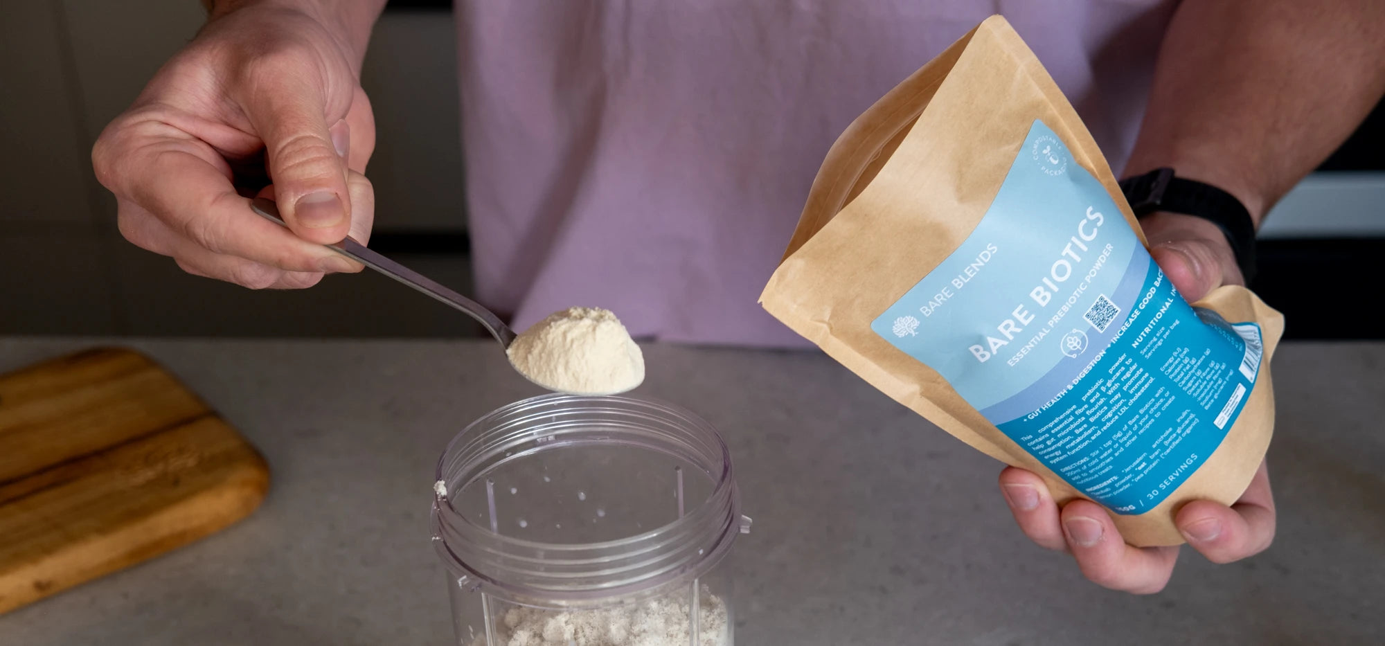 Bare Biotics pouch held beside a spoon of powder above a blender cup